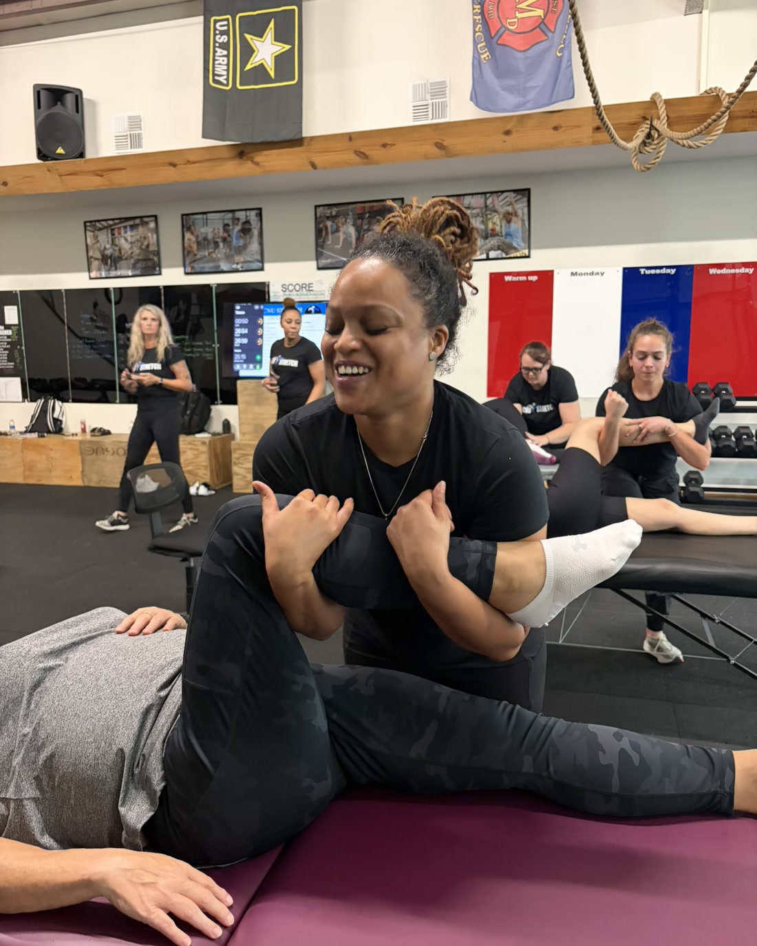 Working a client through an assisted stretch, hands supporting the knee